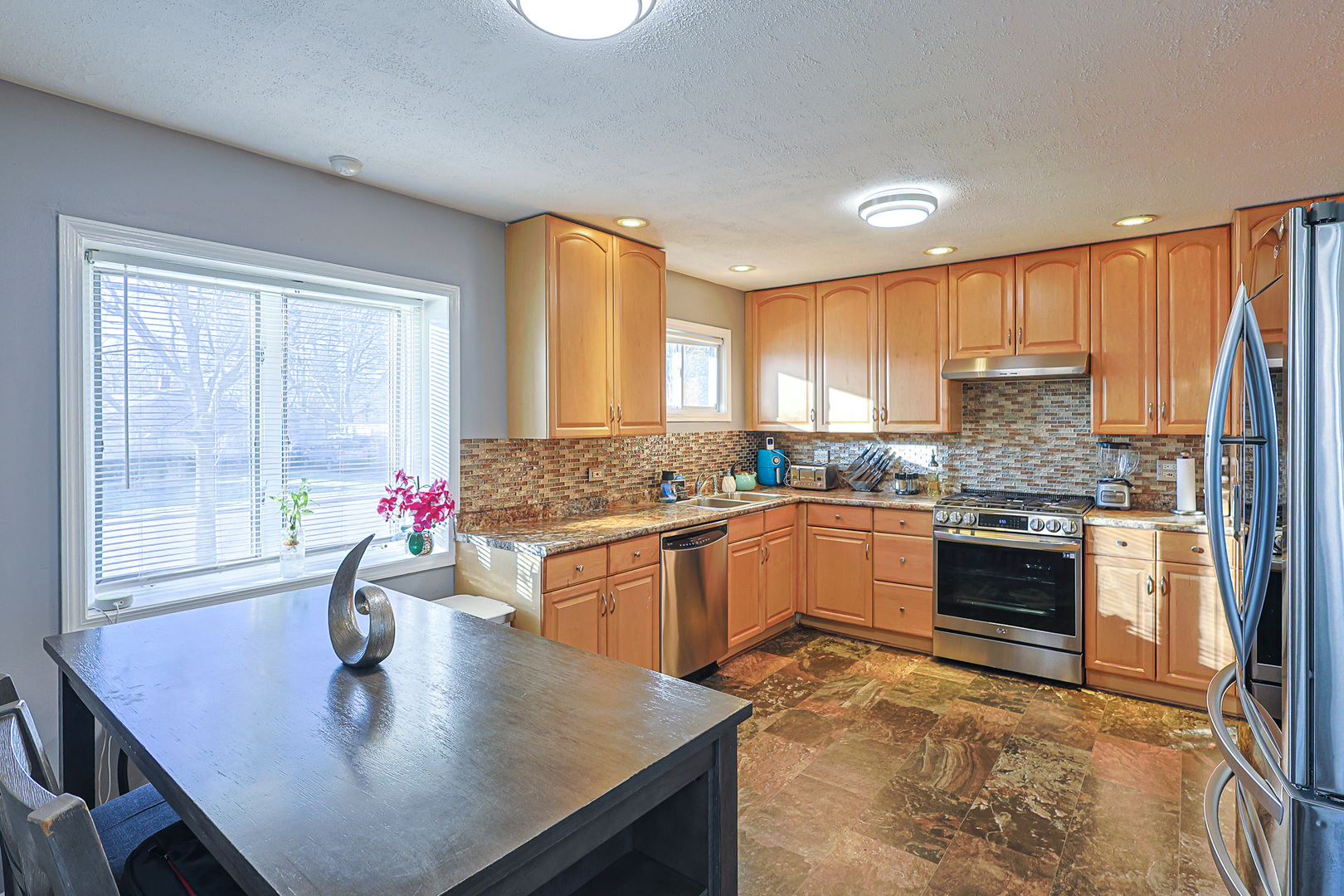 1501 Pawnee Road Carpentersville, IL 60110 - Photo 11 of 22 a kitchen with kitchen island granite countertop a stove a sink a counter space and dining table