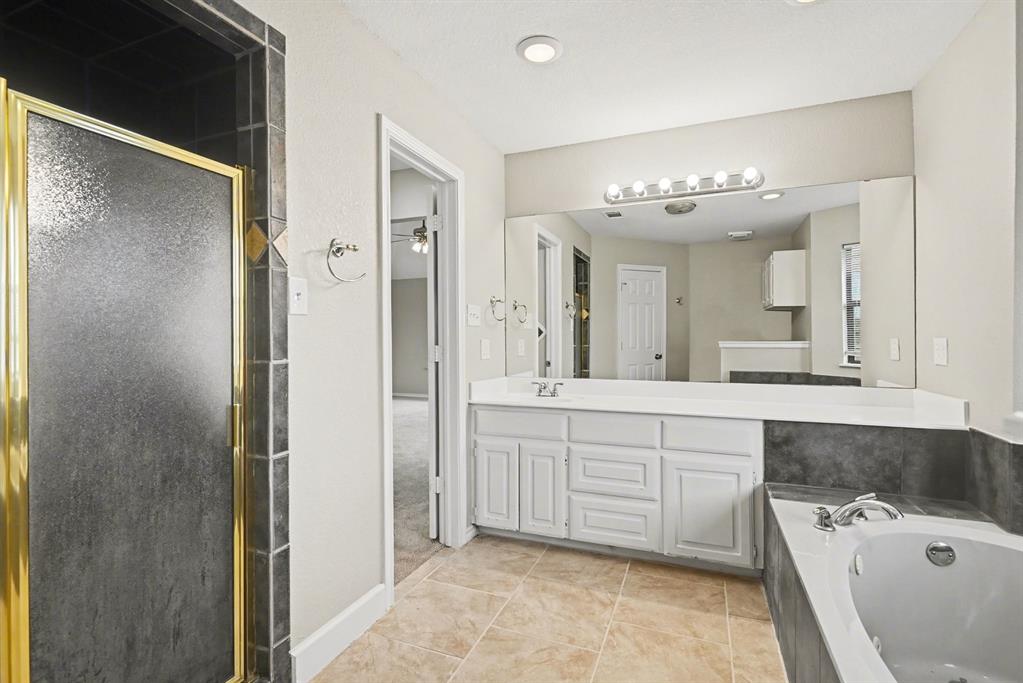 10101 Round Hill Road Fort Worth, TX 76131 - Photo 12 of 30 a spacious bathroom with a tub sink and mirror