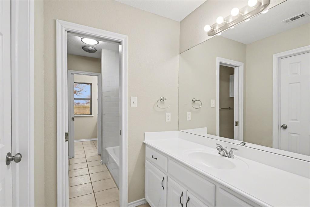 10101 Round Hill Road Fort Worth, TX 76131 - Photo 18 of 30 a spacious bathroom with a shower sink and mirror