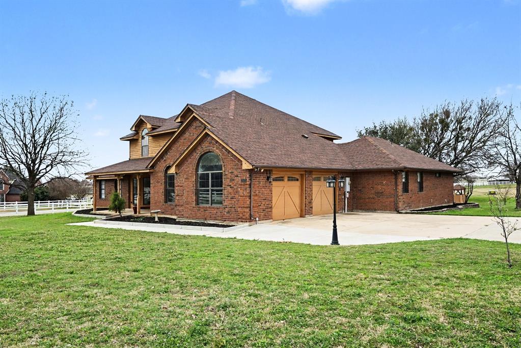 10101 Round Hill Road Fort Worth, TX 76131 - Photo 2 of 30 a front view of a house with a yard and garage