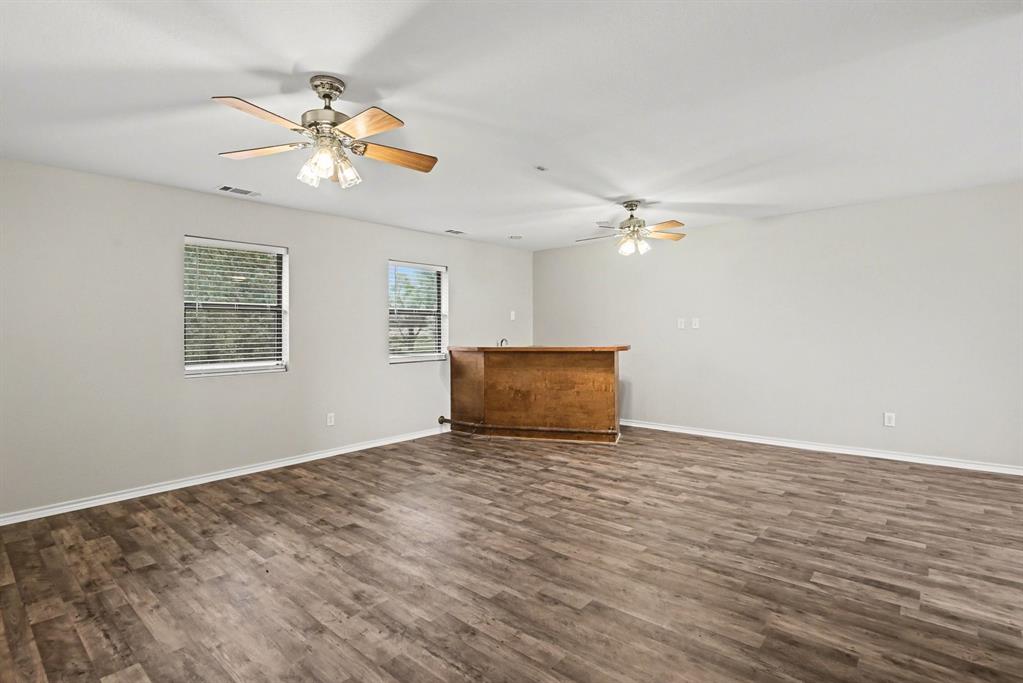 10101 Round Hill Road Fort Worth, TX 76131 - Photo 21 of 30 a view of wooden floor and chandelier fan in a room