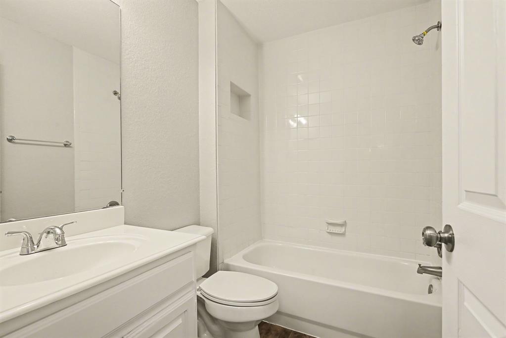10101 Round Hill Road Fort Worth, TX 76131 - Photo 24 of 30 a bathroom with a granite countertop bathtub shower sink vanity mirror and toilet