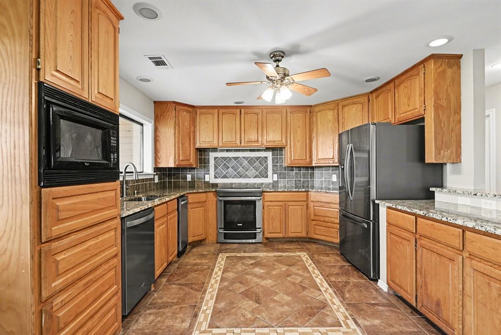 10101 Round Hill Road Fort Worth, TX 76131 - Photo 7 of 30 a kitchen with stainless steel appliances granite countertop a refrigerator stove microwave and sink