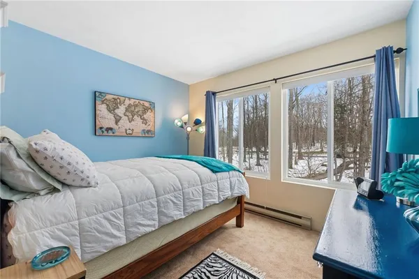 a bedroom with a bed and a large window with outer view