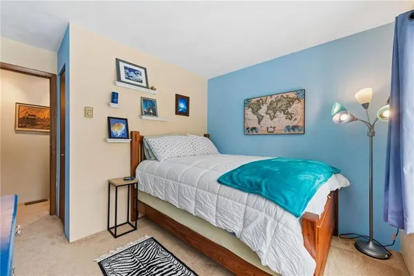 a bedroom with a bed and a painting on the wall