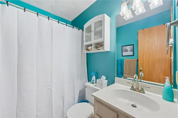 a bathroom with a sink mirror and a toilet
