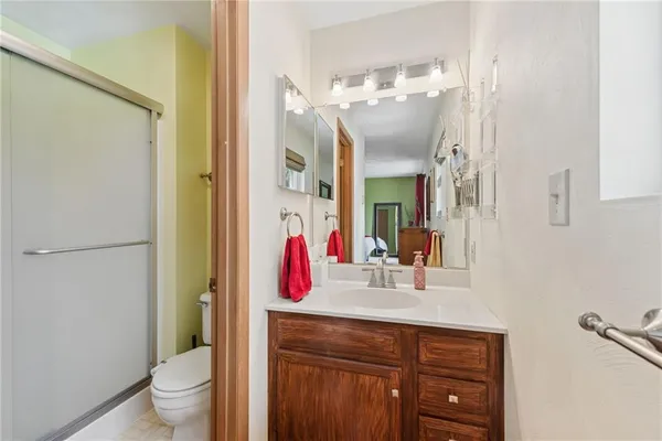 a bathroom with a granite countertop sink a toilet and a mirror