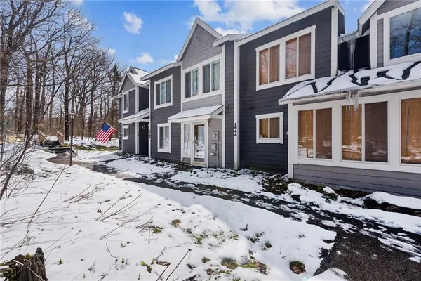 a view of a brick house with a large tree in front of it