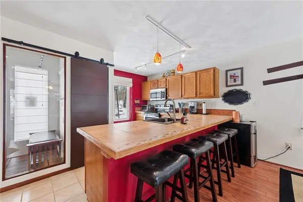 a kitchen with stainless steel appliances a table and chairs in it