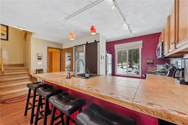 a view of a dining room with furniture a chandelier and kitchen view