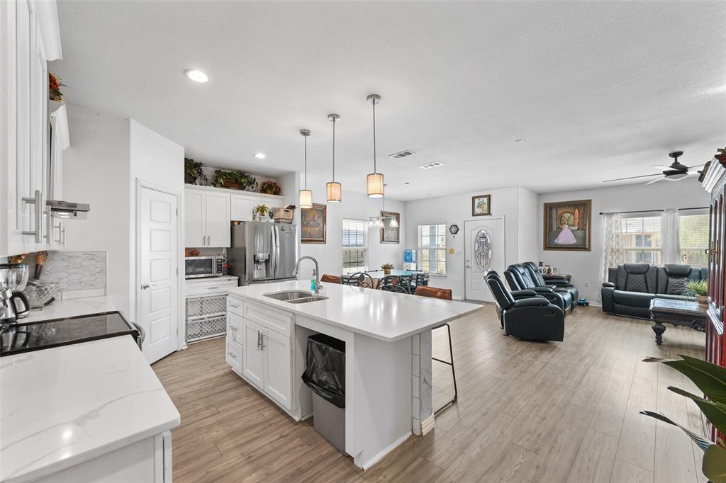 0 Ewing Road Ferris, TX 75125 - Photo 6 of 29 Open-concept kitchen featuring white cabinetry, quartz countertops, a large island with sink, stainless steel appliances, and recessed lighting