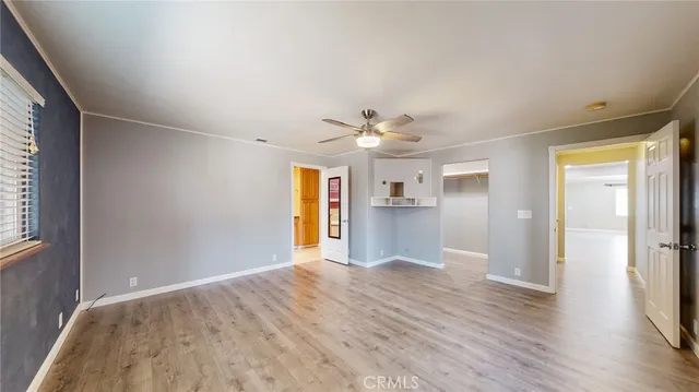 a view of a big room with wooden floor and windows