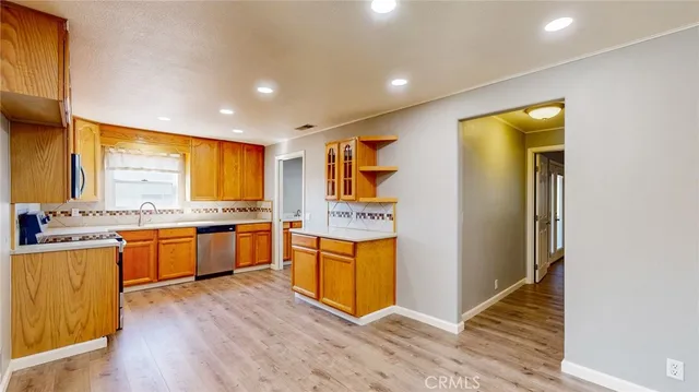 a large kitchen with stainless steel appliances granite countertop a large window and a sink