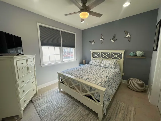 a bedroom with a bed and flat tv screen on the dresser