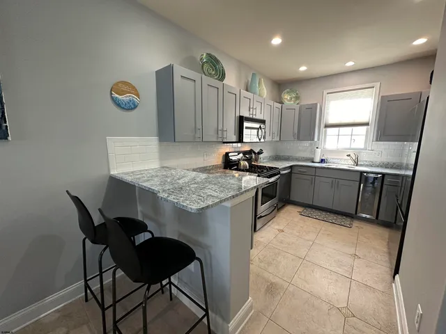 a kitchen with granite countertop sink stove and cabinets