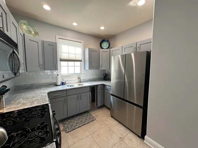 a kitchen with stainless steel appliances granite countertop a refrigerator sink and stove