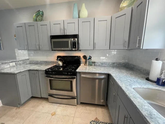 a kitchen with stainless steel appliances granite countertop a sink stove and cabinets