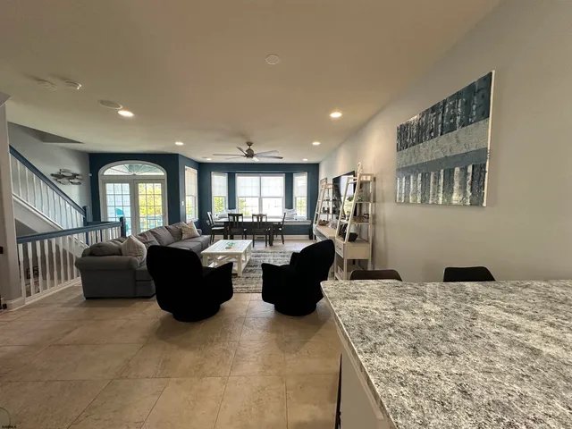 a living room with couches a kitchen view and living room