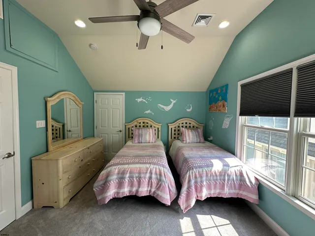 a bedroom with two beds and a chandelier