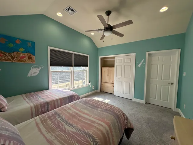 a bedroom with 2 bed and a window