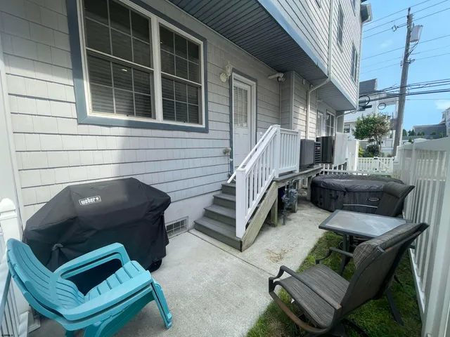 a view of a patio with couches chairs and wooden floor