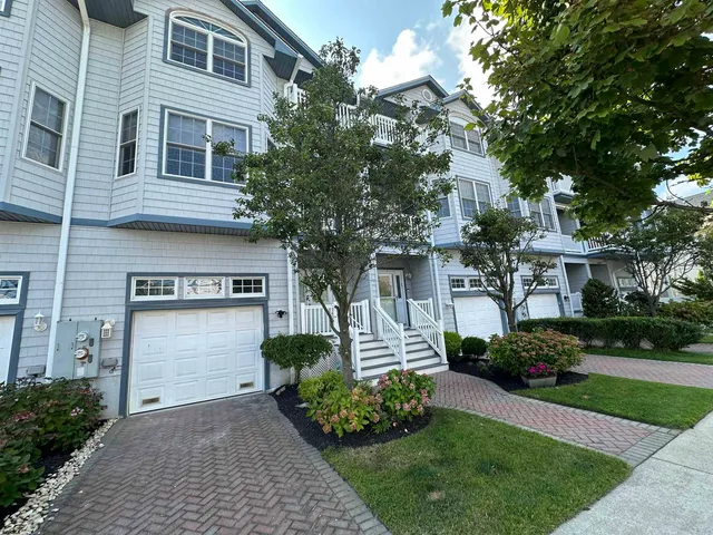 a front view of a house with a garden and plants