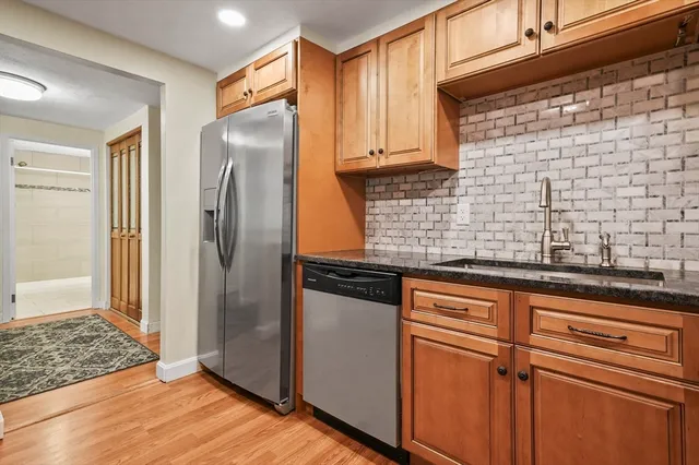 a kitchen with stainless steel appliances granite countertop a refrigerator and a sink