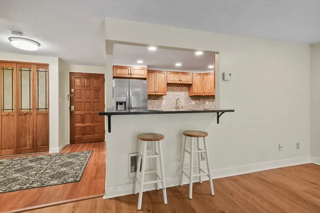 a kitchen with kitchen island granite countertop wooden floor and white cabinets