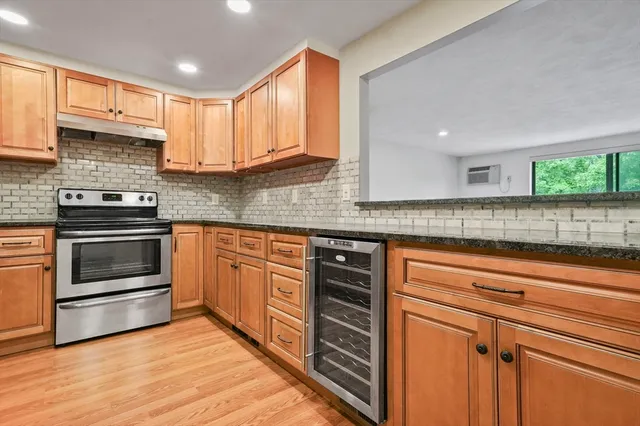a kitchen with granite countertop wooden cabinets stainless steel appliances and a counter space