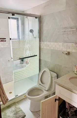 a bathroom with a granite countertop toilet sink and mirror