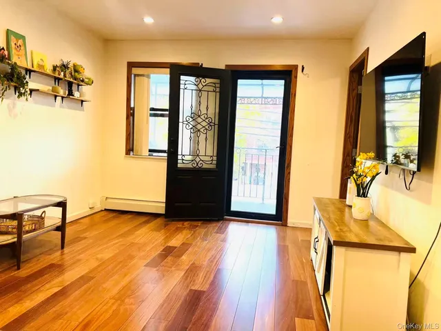 a view of a livingroom with furniture hardwood floor and windows