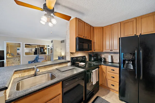 a kitchen with stainless steel appliances granite countertop a sink a stove and refrigerator