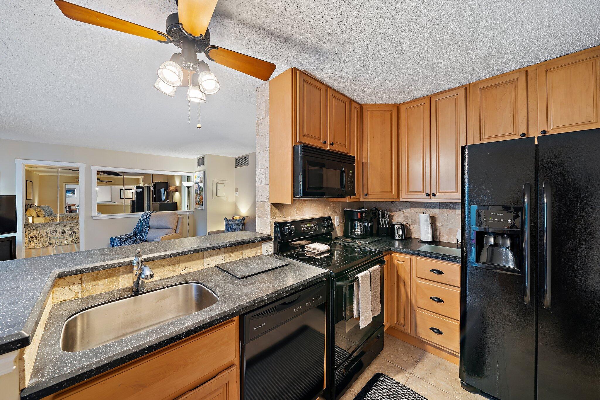 1605 Highway 1, Unit SL5A Jupiter, FL 33477 - Photo 13 of 26 a kitchen with stainless steel appliances granite countertop a sink a stove and refrigerator