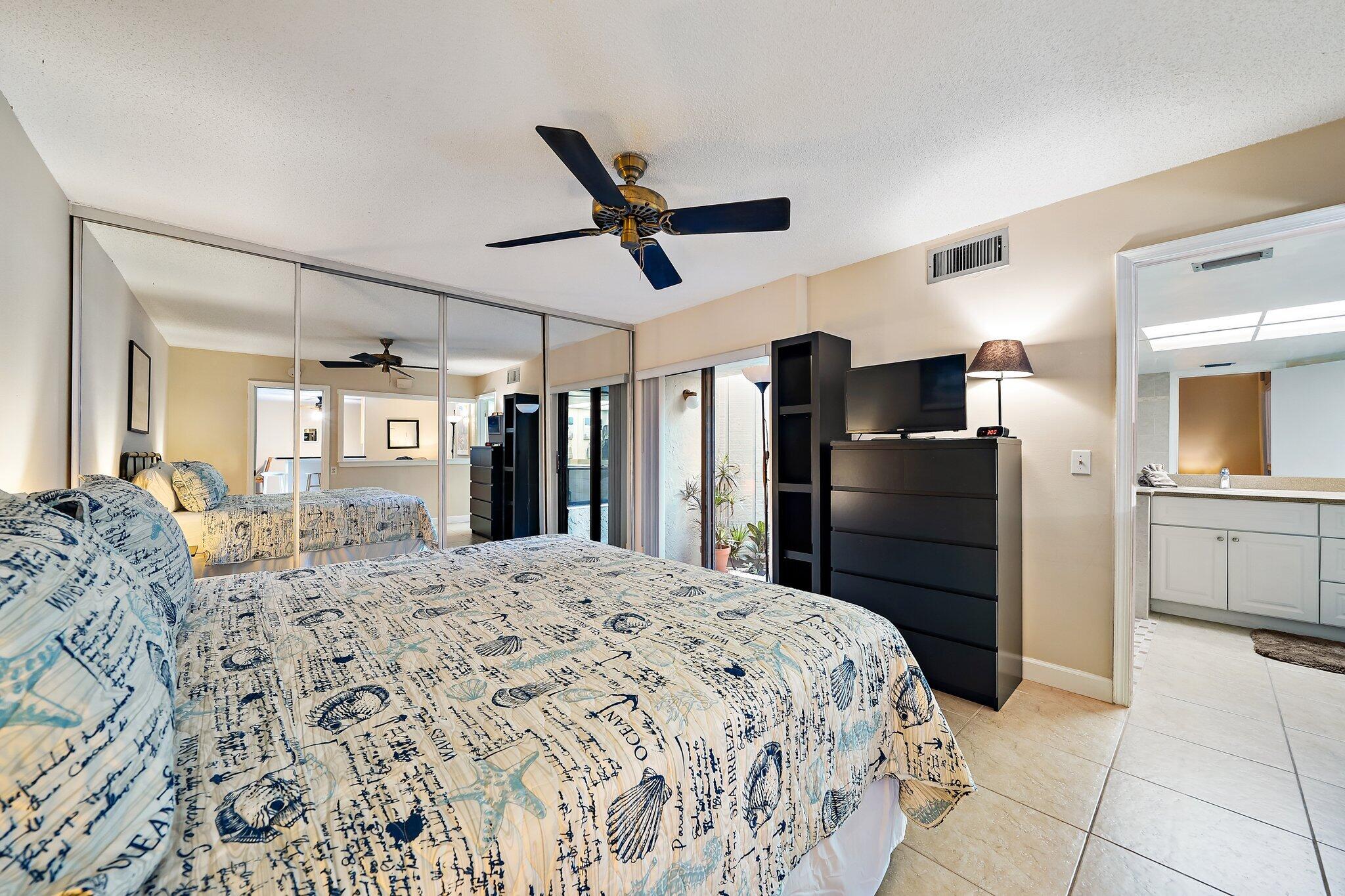 1605 Highway 1, Unit SL5A Jupiter, FL 33477 - Photo 16 of 26 a large bedroom with a bed and a television