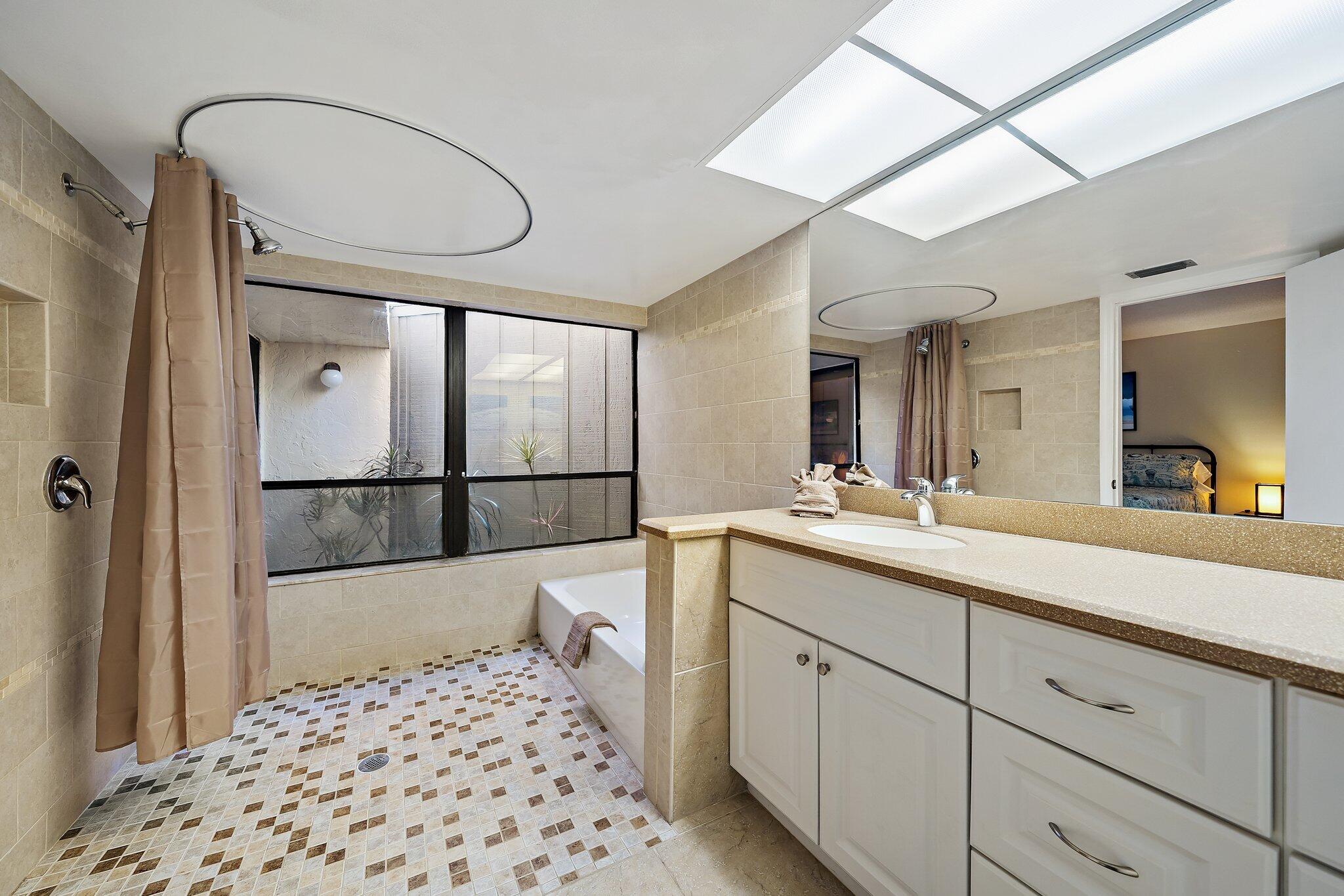 1605 Highway 1, Unit SL5A Jupiter, FL 33477 - Photo 19 of 26 a en suite bathroom with a sink a mirror a window and a shower