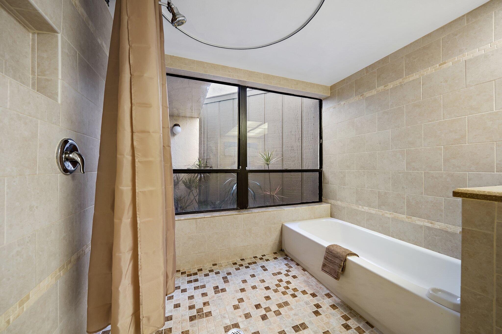 1605 Highway 1, Unit SL5A Jupiter, FL 33477 - Photo 20 of 26 a bathroom with a bathtub and a shower