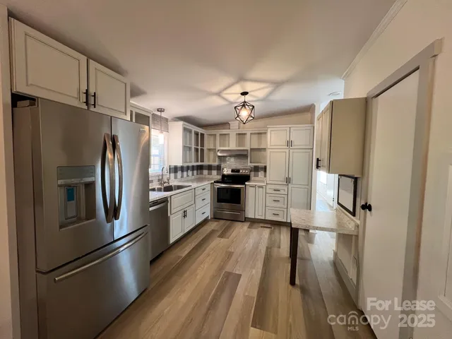 a kitchen with stainless steel appliances a refrigerator and a stove top oven