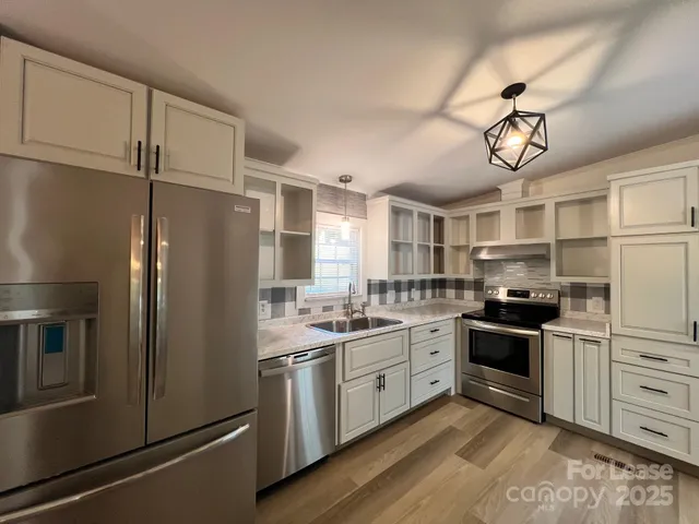 a kitchen with stainless steel appliances a stove a sink and refrigerator