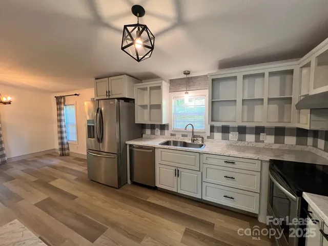 a view of a kitchen with a stove wooden floor a kitchen view
