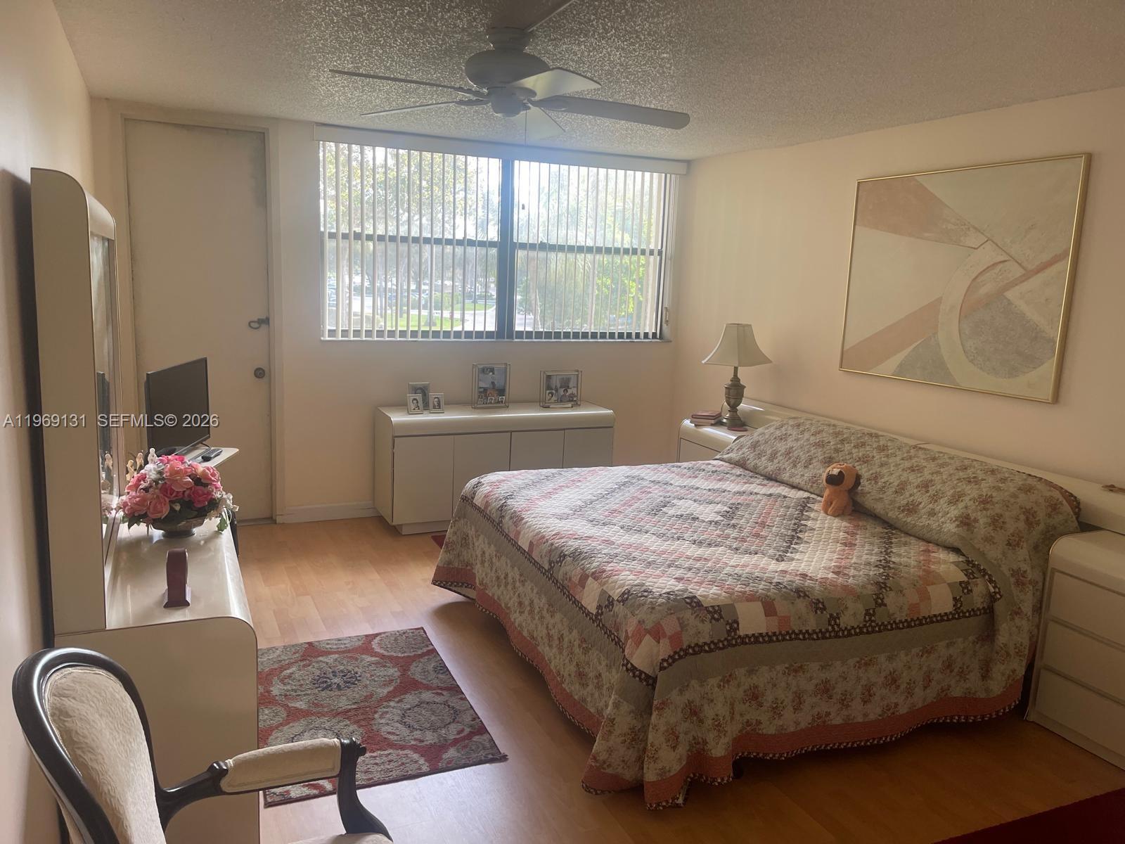 16500 Golf Club Road, Unit 204 Weston, FL 33326 - Photo 14 of 26 a bedroom with a bed dresser flowerpot and window