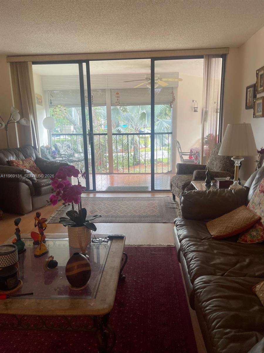 16500 Golf Club Road, Unit 204 Weston, FL 33326 - Photo 17 of 26 a living room with furniture and a floor to ceiling window