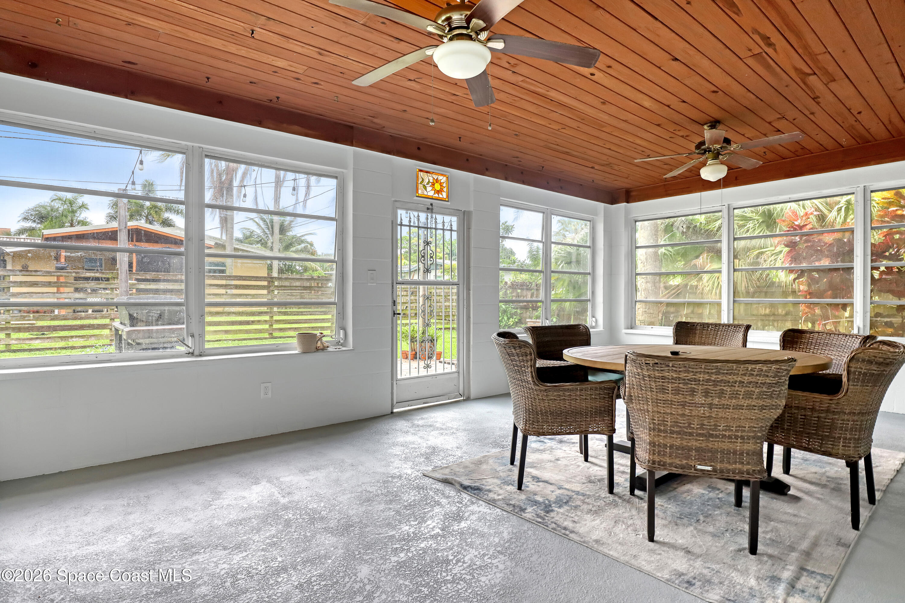 2307 Country Club Road Melbourne, FL 32901 - Photo 27 of 44 a dining room with furniture large windows and wooden floor