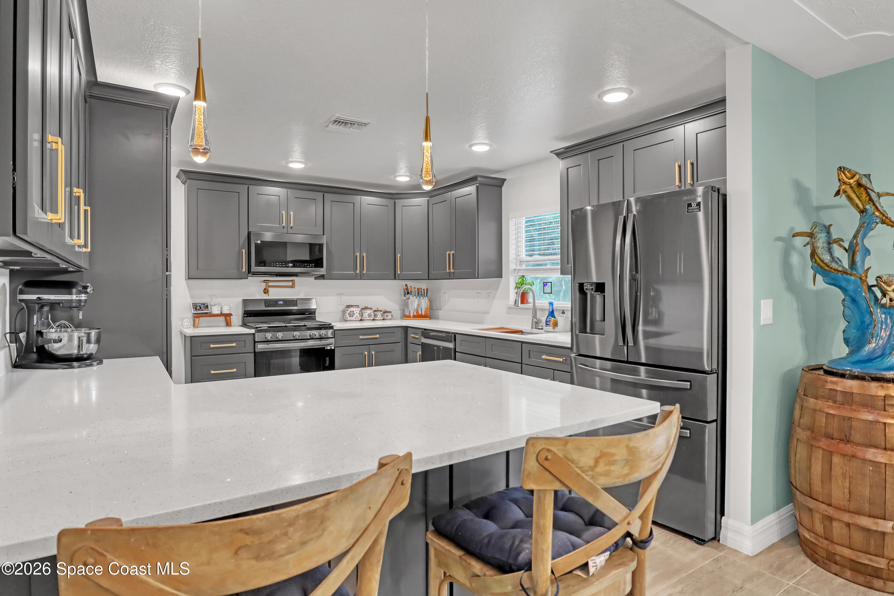 2307 Country Club Road Melbourne, FL 32901 - Photo 32 of 44 a kitchen with stainless steel appliances a refrigerator a stove a sink cabinets and a dining table