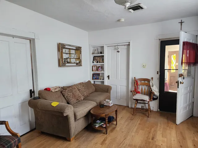 a living room with furniture and a wooden floor