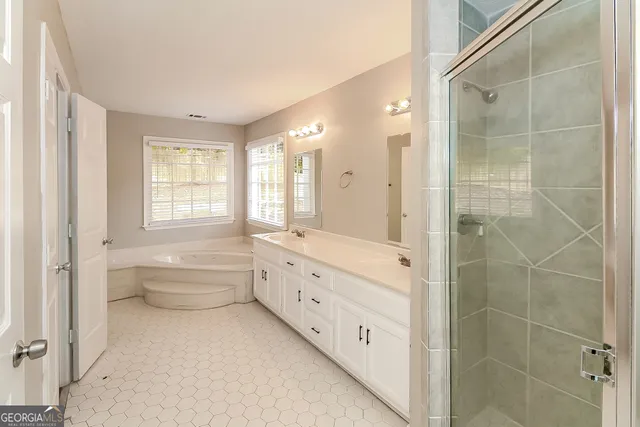 a bathroom with a double vanity sink toilet next to a window