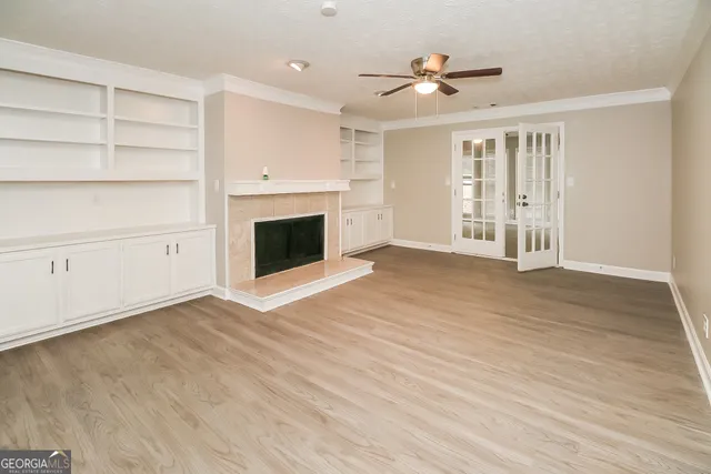 a view of an empty room with a fireplace and a window