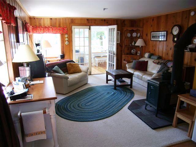 156 Kibbe Road Otis, MA 01029 - Photo 4 of 6 a living room with furniture a large window with kitchen view and a fireplace