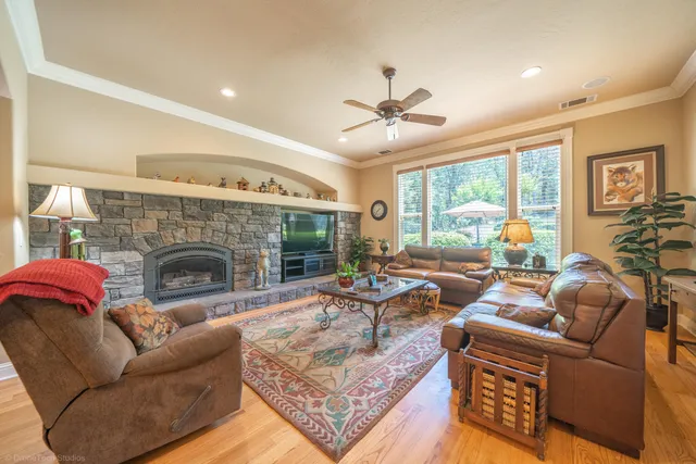 a living room with furniture a fireplace and a floor to ceiling window