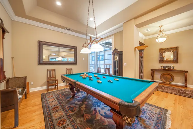a room with pool table and windows