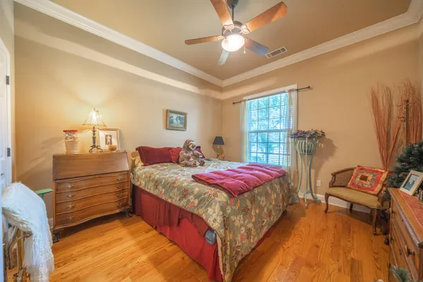 a spacious bedroom with a bed and a chandelier